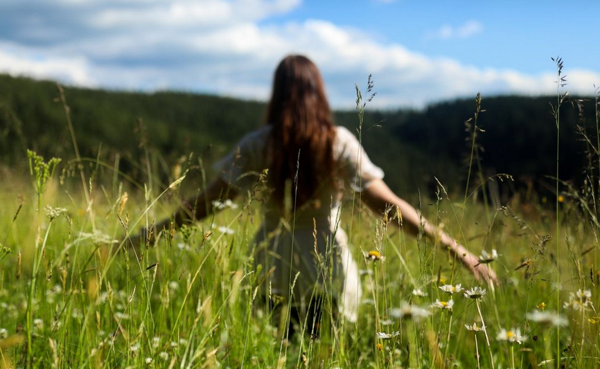 faerie like girl in touch with nature behind gras