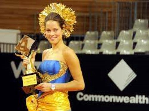 Ana Ivanovic of Serbia wearing traditional Balinese dress holds up the trophy