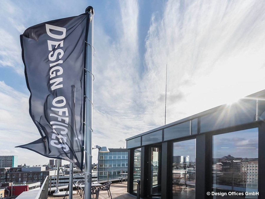 Design Offices Hamburg – Moderne Bürofläche mit Dachterrasse in zentraler Innenstadtlage Panoramablick auf die Dachterrasse der Design Offices in Hamburg mit moderner Glasfassade und Stadtblick bei Sonnenschein.