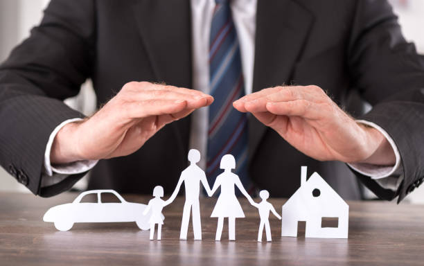 hands hovering over car and house and family