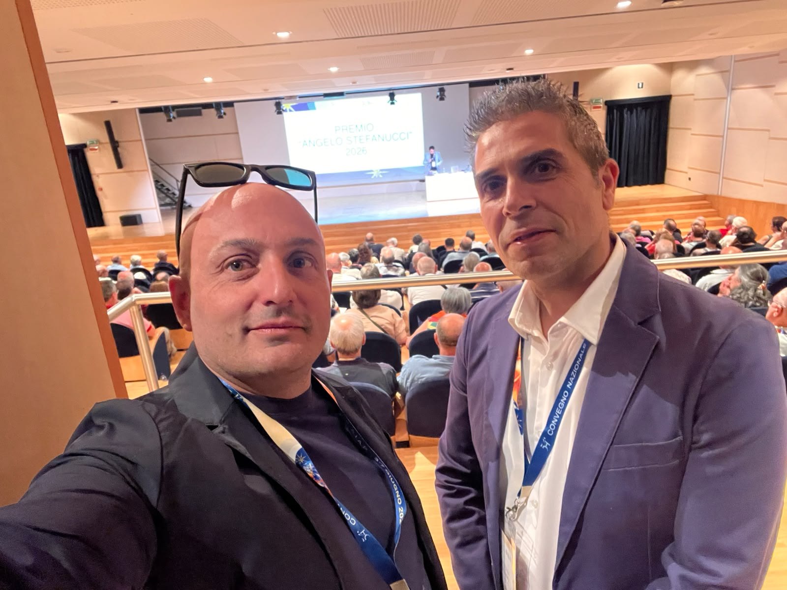 Foto di gruppo in un auditorium durante un evento