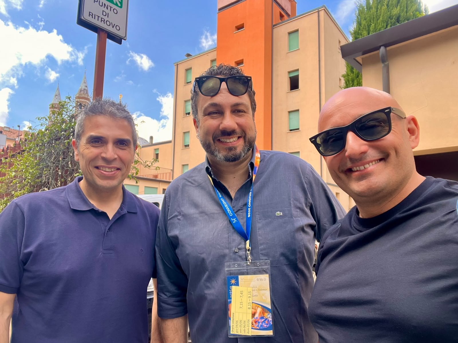 Foto di gruppo all’esterno con badge di un convegno