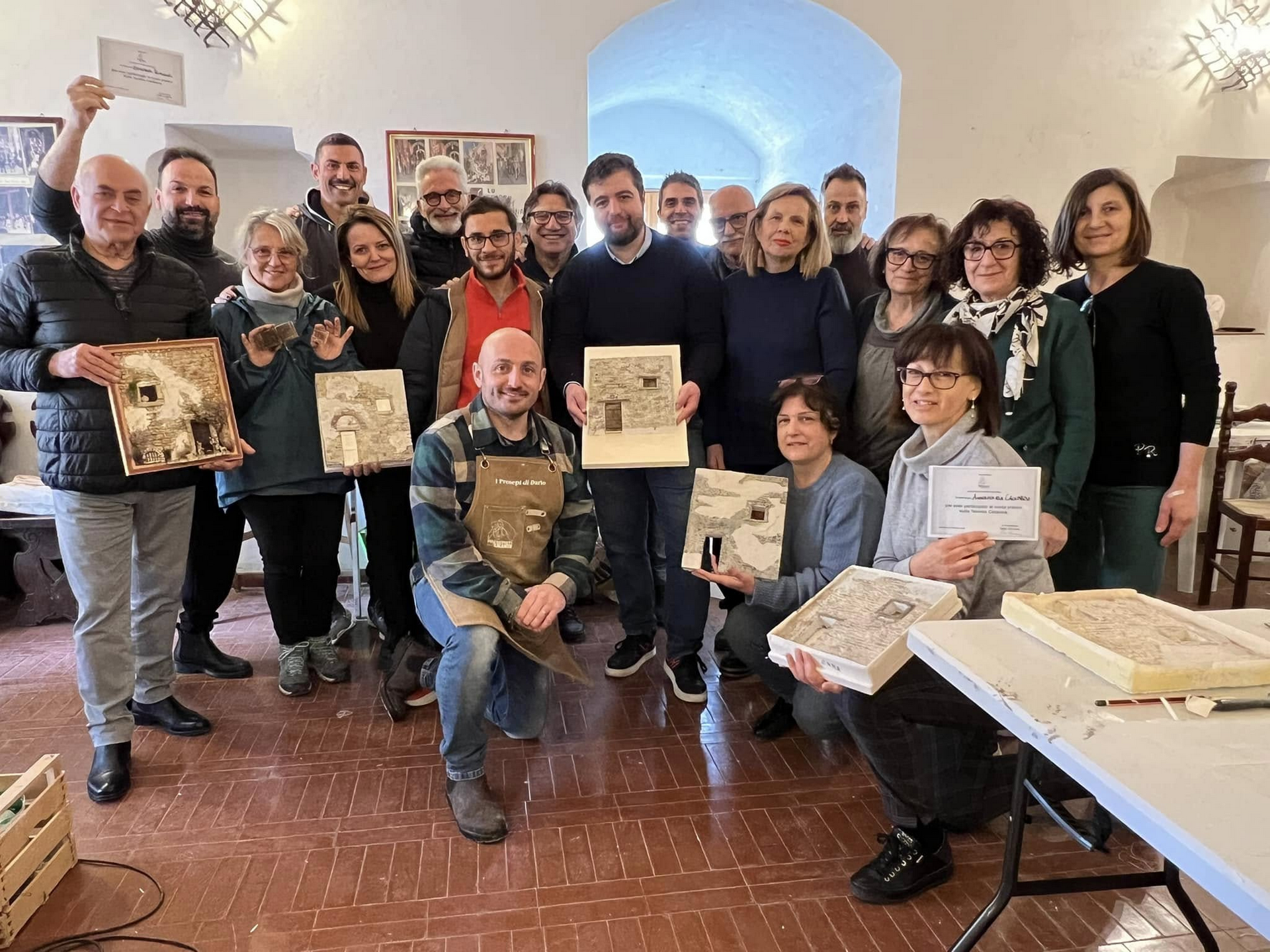 Scenografie e personaggi di presepe esposti sul tavolo di uno studio televisivo